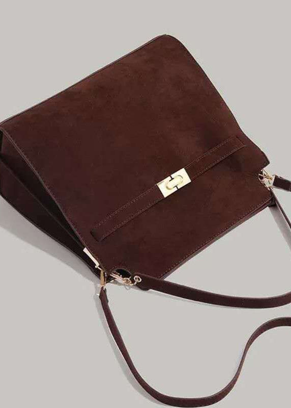 Brown suede handbag with a gold clasp on a light gray background